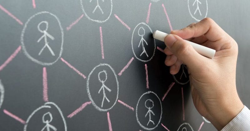 a teacher writing on a chalkboard to represent the connections of a PLN